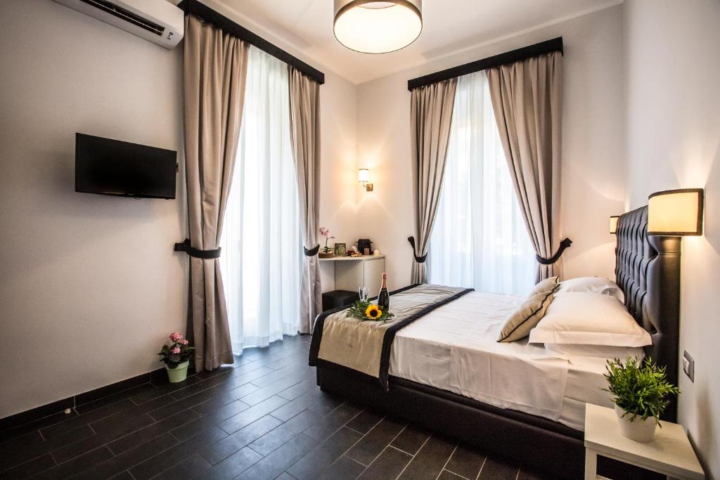 羅馬的住宿－聖彼得羅休閒豪華旅館，一间卧室配有一张带窗帘的床和电视。