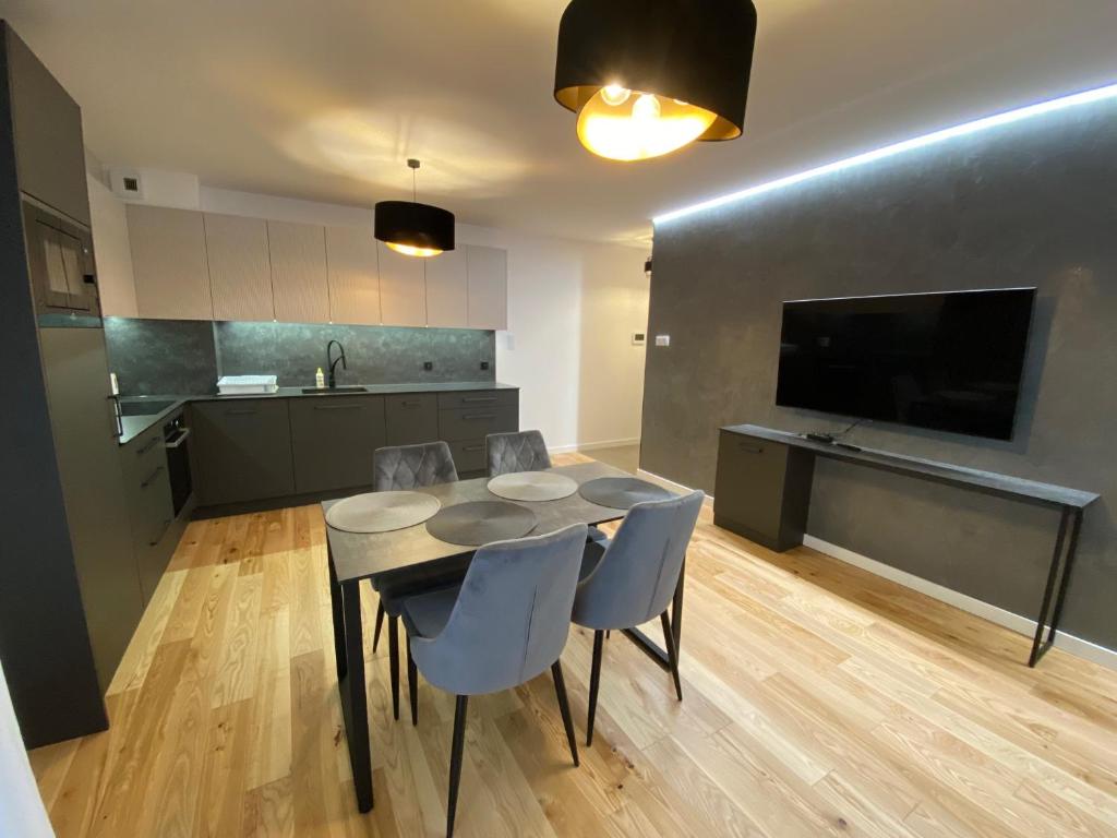 a kitchen and dining room with a table and chairs at Vistula Avenue Apartment Free Parking in Krakow