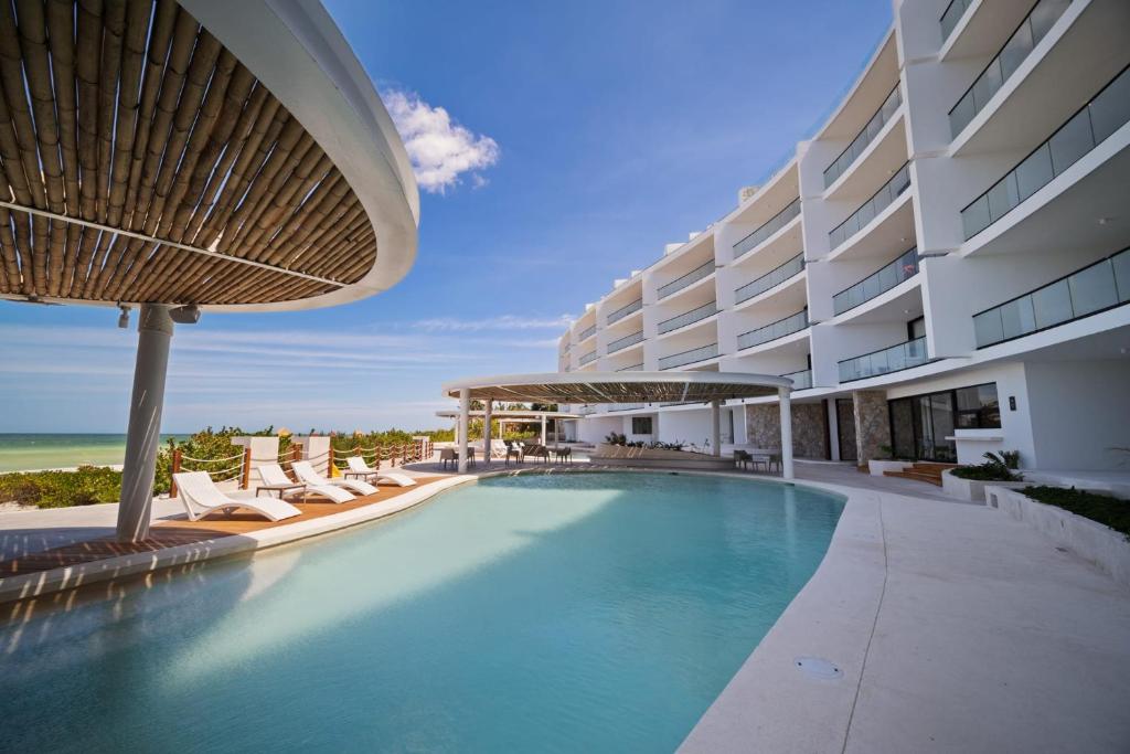 a swimming pool in front of a building with chairs at SIELA Oceanfront Luxury 4 BR Villa in San Bruno