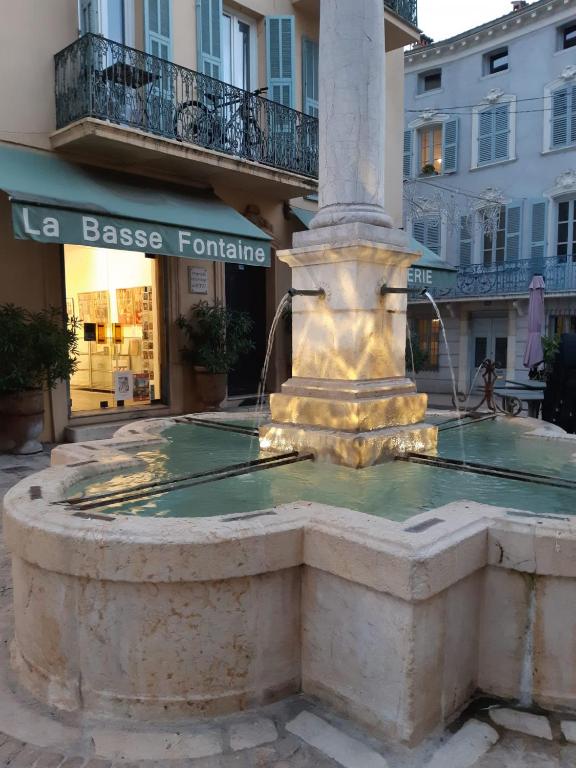 une fontaine dans une rue en face d'un bâtiment dans l'établissement Basse Fontaine, à Vence