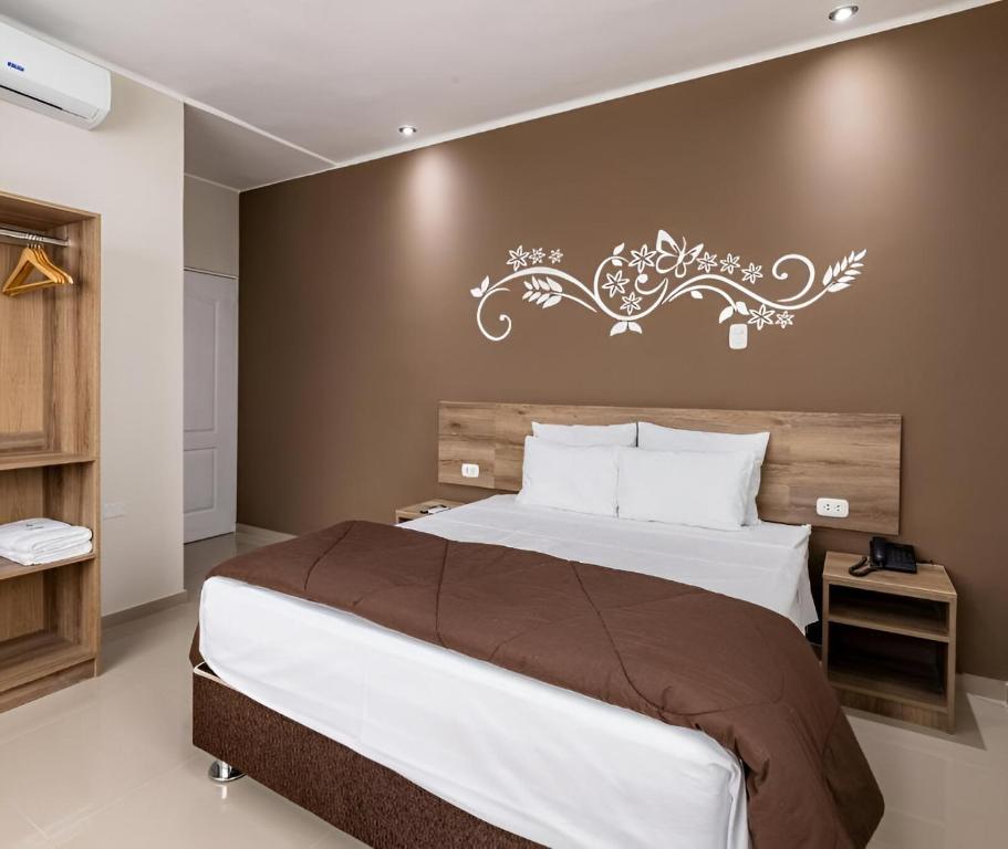 a bedroom with a large bed with a wall at Hotel Solec Piura in Piura