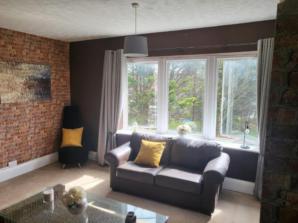 a living room with a couch and two windows at Jubilee pub in Litherland