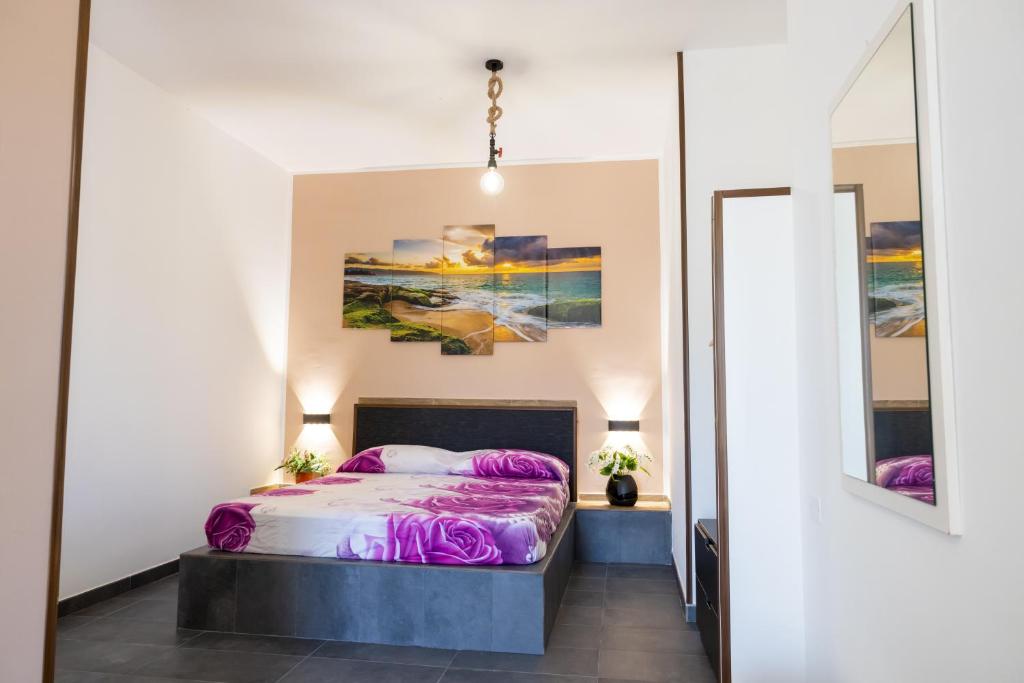 een slaapkamer met een bed met paarse kussens bij Dimora Flaminio in Peschici