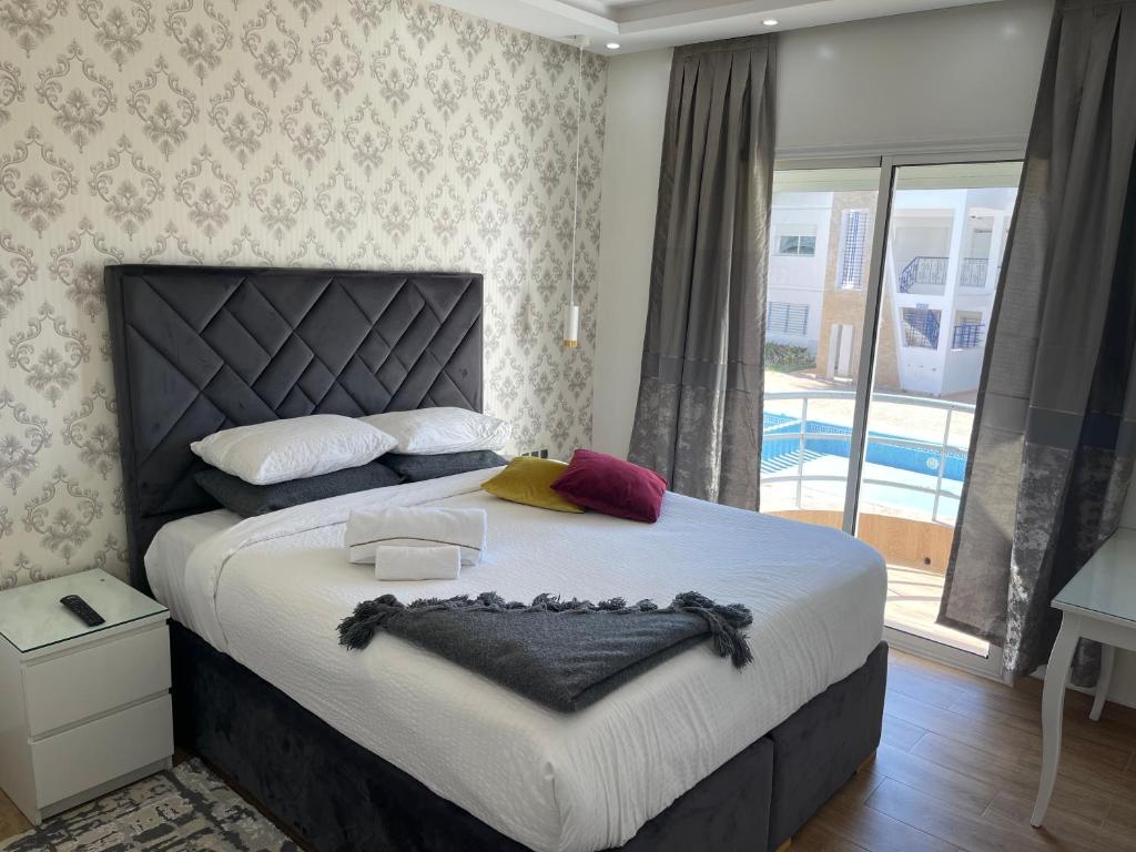 1 dormitorio con 1 cama grande y piscina en Appartement Bousaid, en Oualidia