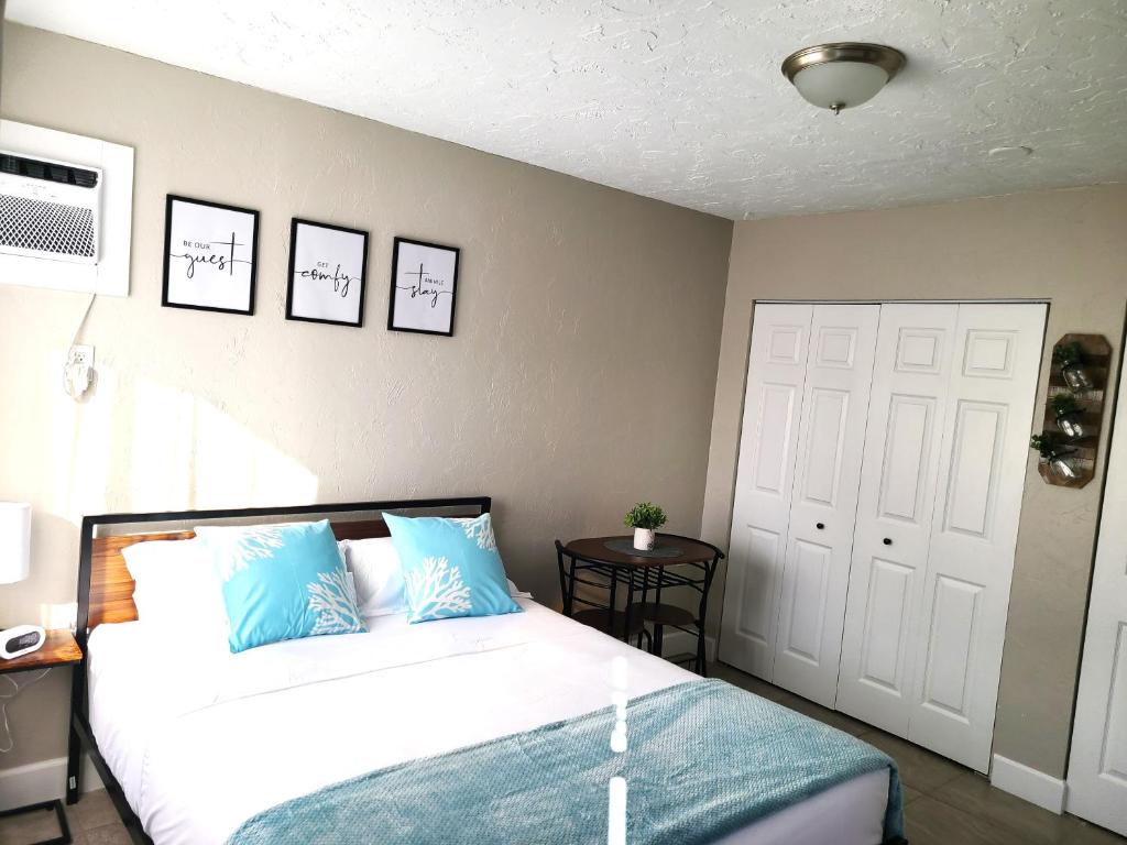 a bedroom with a bed and a door and a table at Studio University Pines at Sarasota in Sarasota