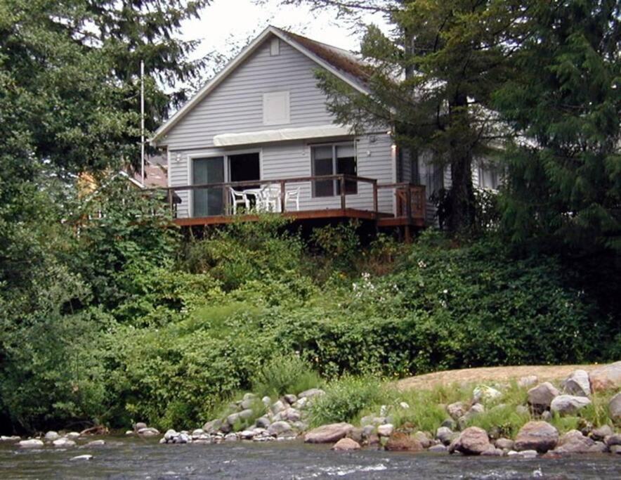 una casa con terraza a orillas de un río en River House in Welches on Mt Hood OR, en Welches