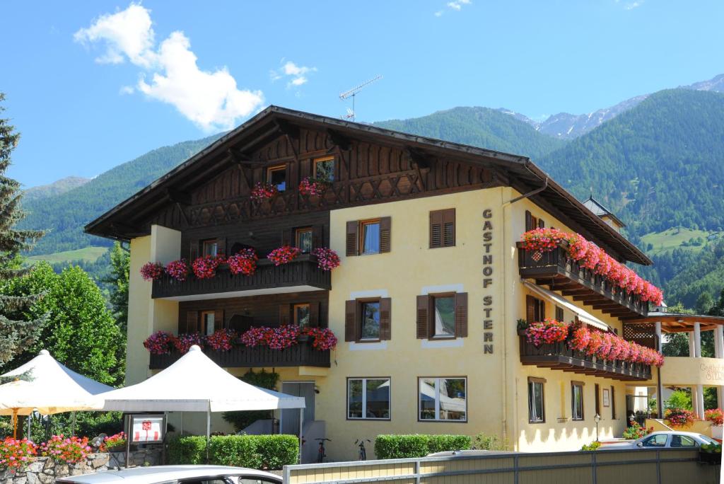 a building with flowers on the balconies of it at Gasthof Stern in Prato allo Stelvio