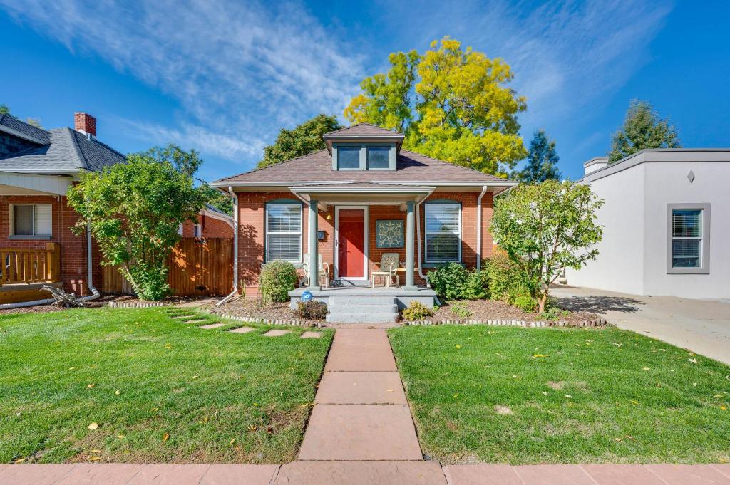 a house with a red door and a yard at Furnished Patio and Yard Denver Bungalow! in Denver