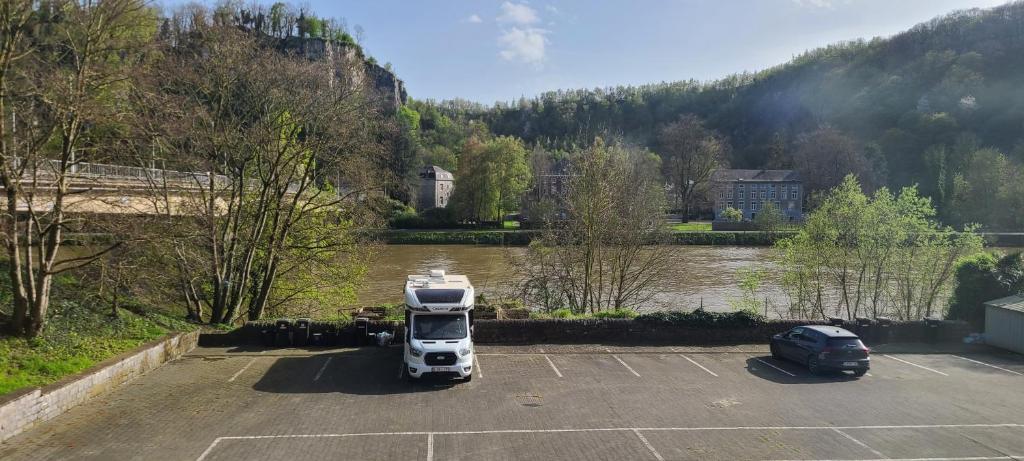 een vrachtwagen geparkeerd op een parkeerplaats naast een rivier bij Chaleureux petit appart entre Namur et Andenne in Namêche