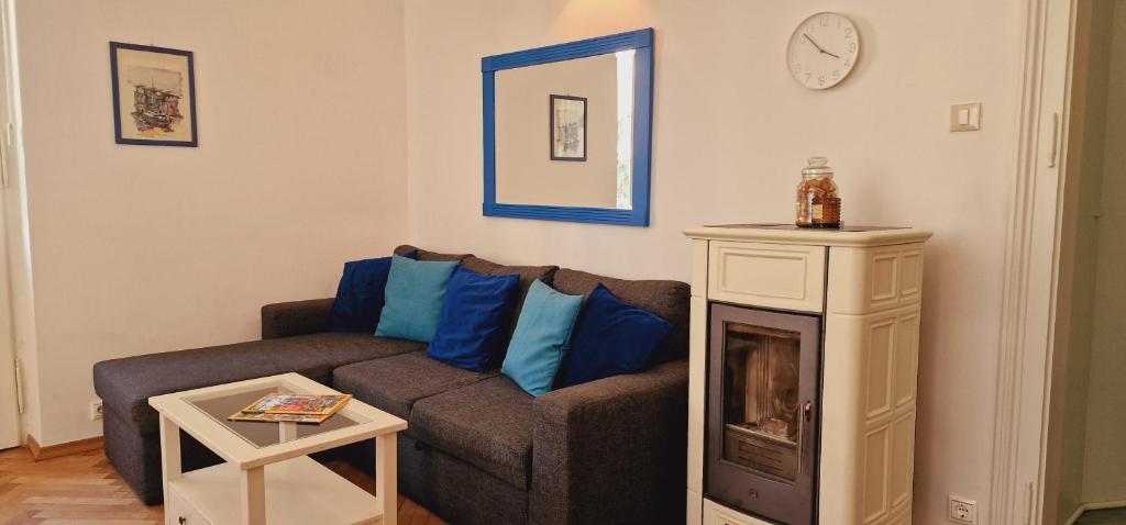 ein Wohnzimmer mit einem Sofa und einer Uhr an der Wand in der Unterkunft Apartment Medea 1 with private parking in Opatija