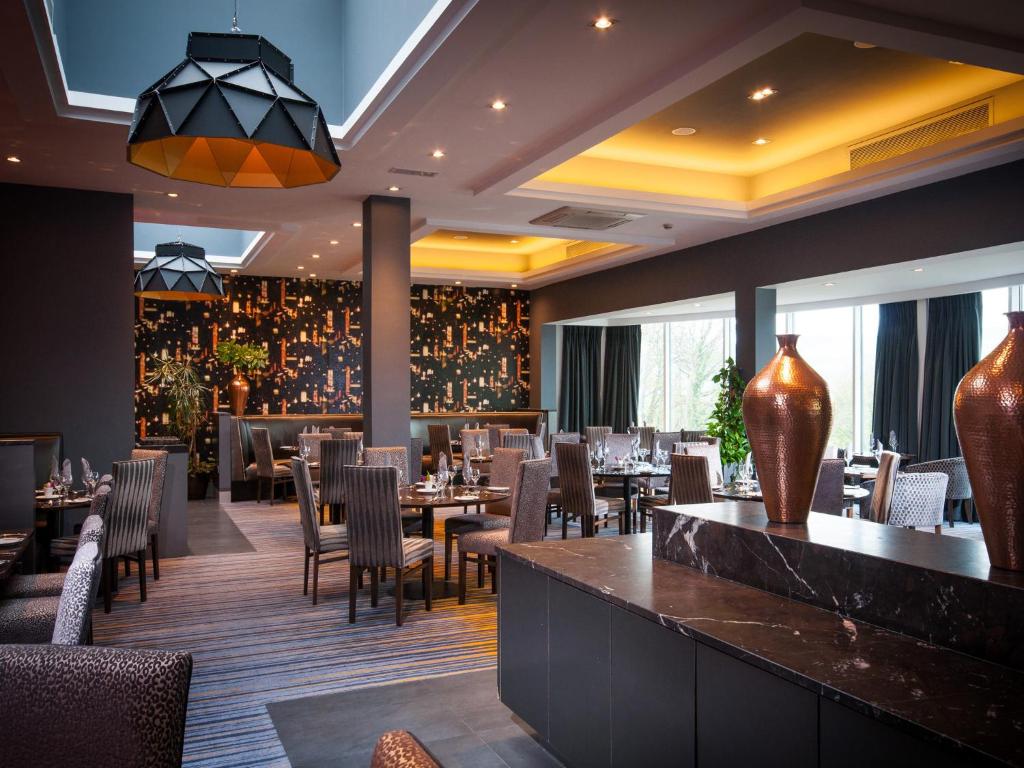 um restaurante com mesas e cadeiras e um bar em Oriel House Hotel em Cork