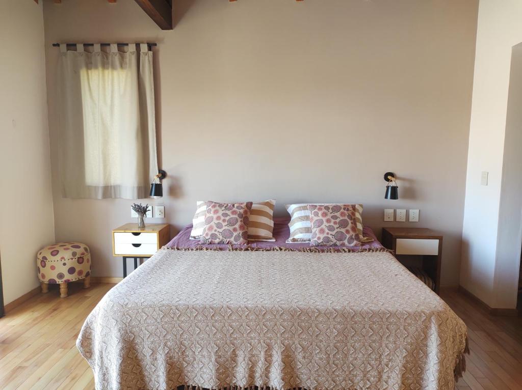 - une chambre avec un lit doté d'un couvre-lit blanc et d'une fenêtre dans l'établissement La Casona, à Cafayate