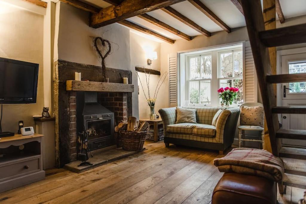 a living room with a fireplace and a couch at 1800 Period Grade 2 Listed Cottage Addingham in Addingham