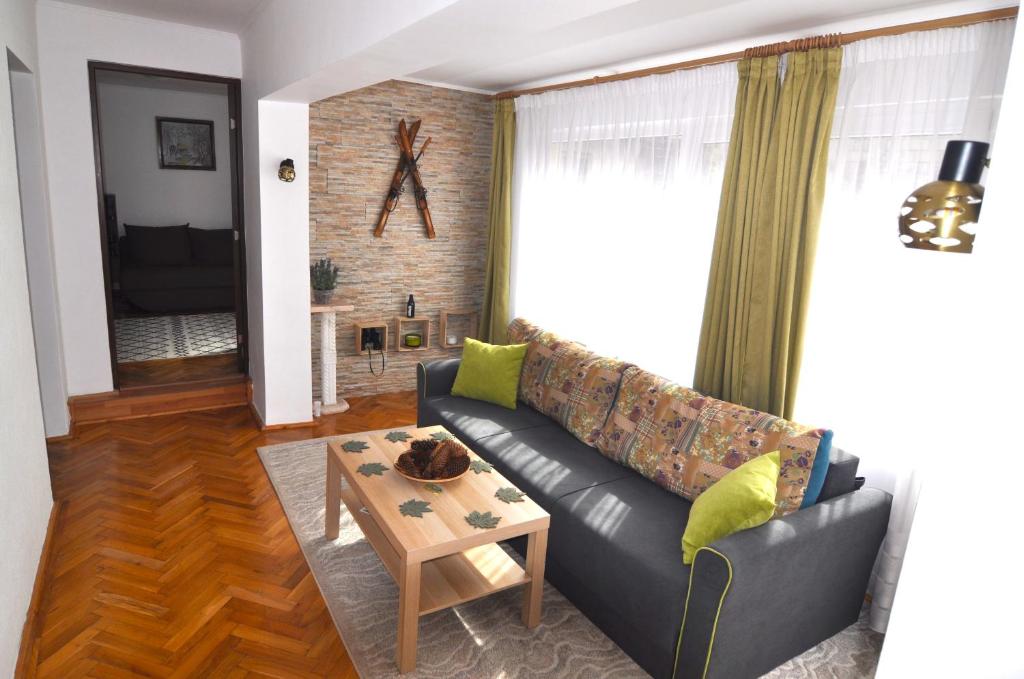 sala de estar con sofá y mesa en Casa TEX en Buşteni
