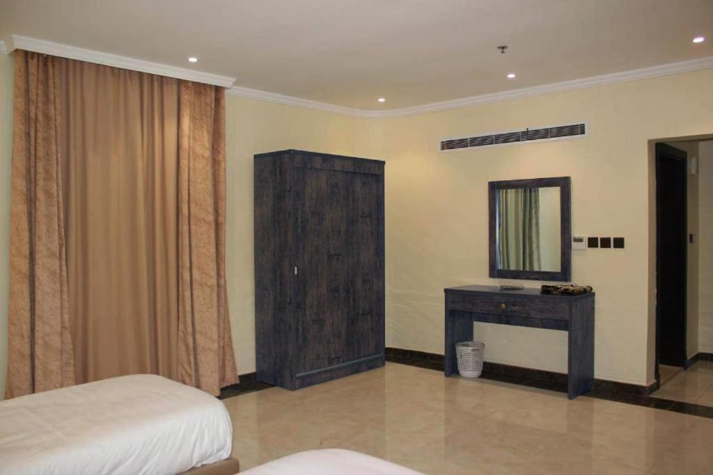 a bedroom with a bed and a dresser and a mirror at كيان حراء للشقق المخدومة- Kayan Hiraa Serviced Apartments in Jeddah