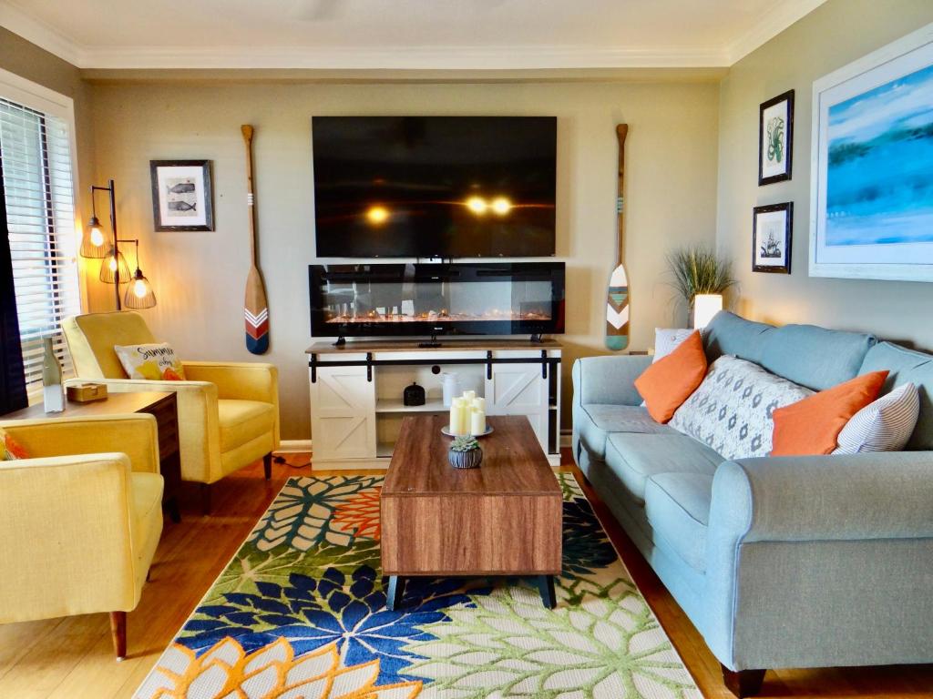 sala de estar con sofá azul y TV en Gorgeous Ocean Views Patio Oasis Resort Amenities, en Myrtle Beach