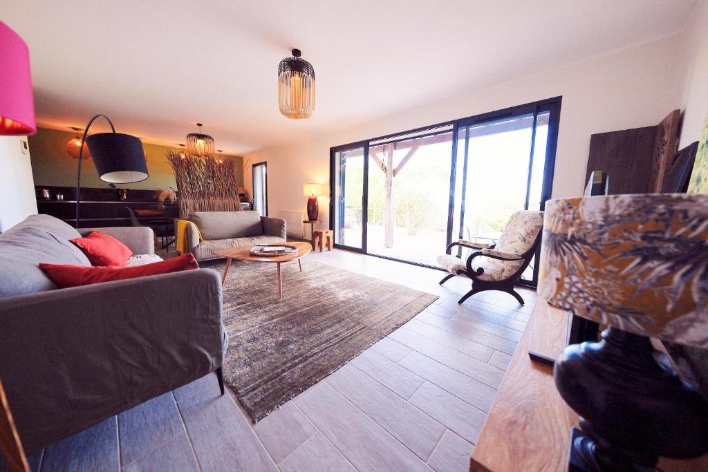 uma sala de estar cheia de mobiliário e uma grande janela em Superbe villa avec piscine et vue mer + Revellata em Calvi