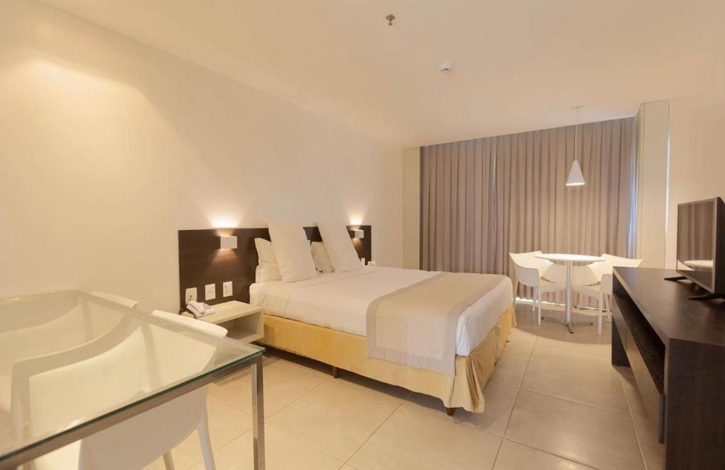 une chambre d'hôtel avec un lit et une baignoire dans l'établissement Lindo Apto beira-mar no Condomínio do Hotel Ritz Suítes Home Service, à Maceió