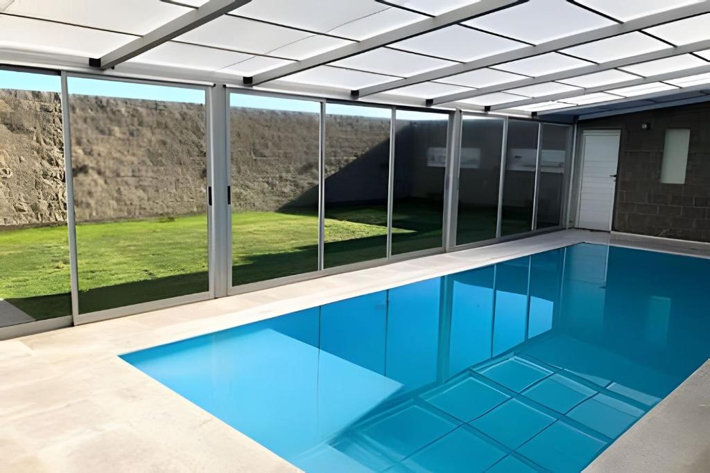 a swimming pool with a view of the mountains through windows at El Galpon de Solana in Puerto Madryn
