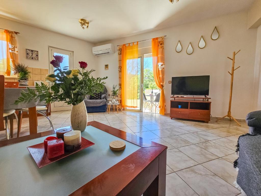 ein Wohnzimmer mit einem Tisch und einem TV in der Unterkunft Rodini Sun Apartment in Rhodos (Stadt)