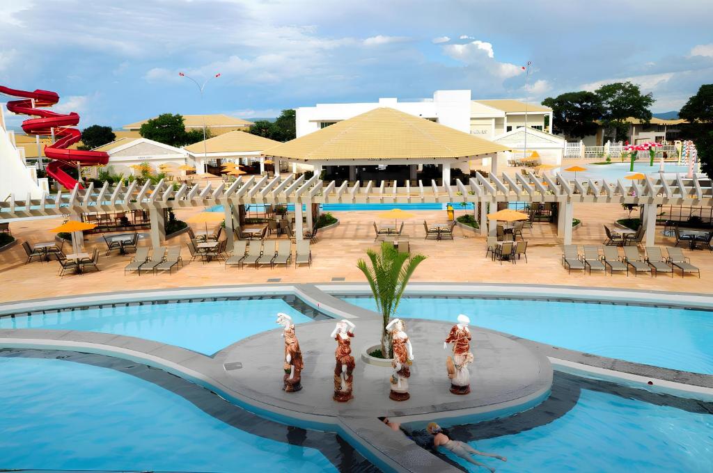una grande piscina con statuette di fronte a un resort di Lacqua Diroma 12345 R1 a Caldas Novas