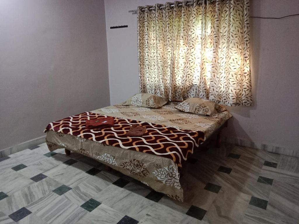 a bed in a room with a window with curtains at Devka villa in Daman