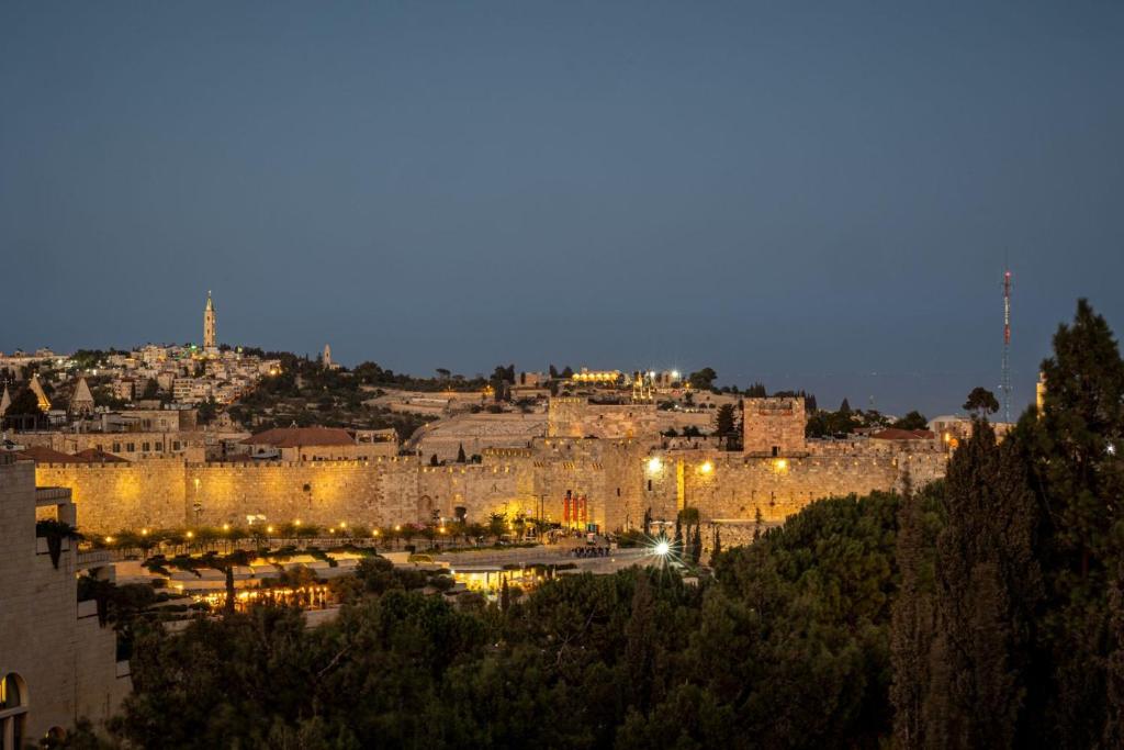 uma vista para uma cidade à noite com luzes em king david residence 131 em Jerusalém