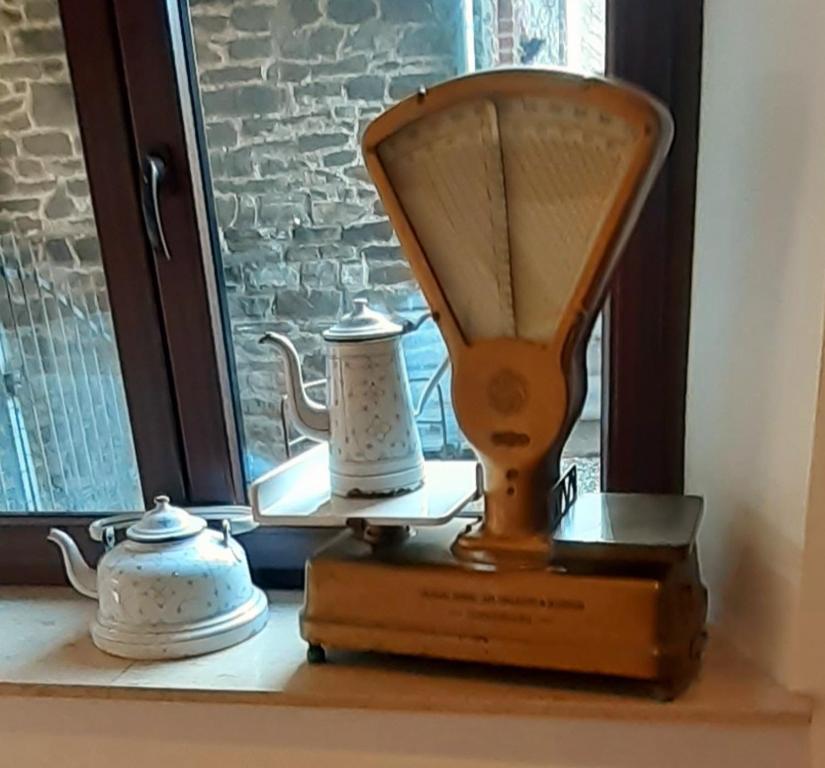 a scale on a window sill with two tea pots at Sous Le Même Toit in Rendeux