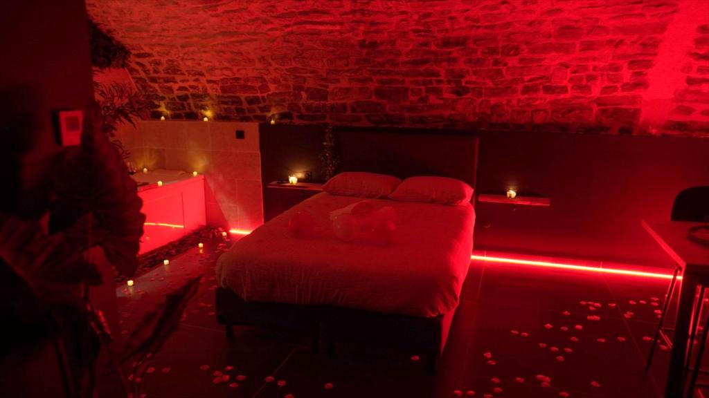 a red room with a bed with red lights at Hébergement insolite, Night Secret Groot in Millau