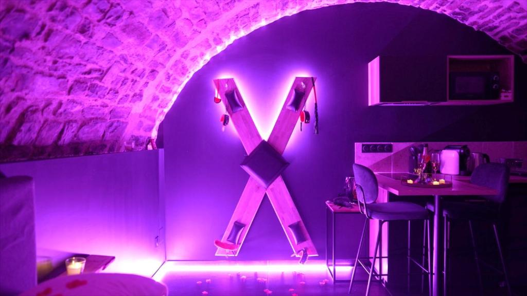 a room with a pink lighted x on the wall at Hébergement insolite, Night Secret Groot in Millau