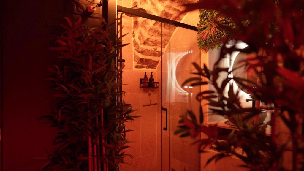 a bathroom with a white door and some plants at Hébergement insolite, Night Secret Groot in Millau