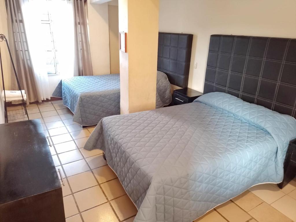 A bed or beds in a room at Hotel Fragata