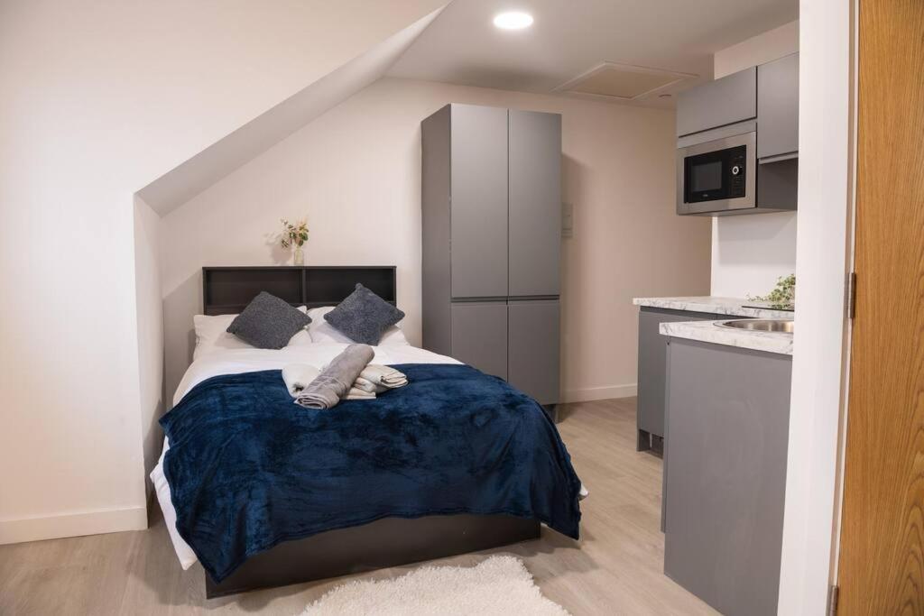 a bedroom with a large bed and a kitchen at Modern Spacious Central Studio in Manchester