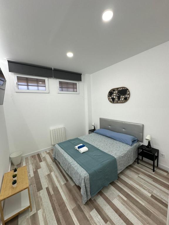 1 dormitorio con 1 cama y suelo de madera en Alojamiento Fantasía, en Madrid