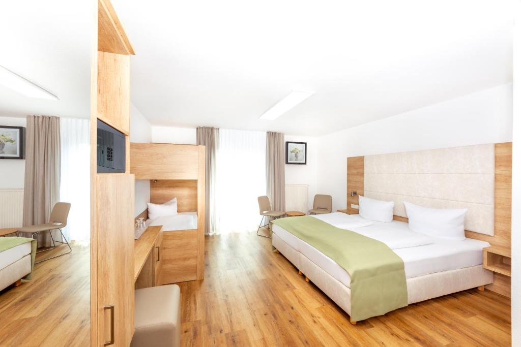 Postel nebo postele na pokoji v ubytování Hotel & Gästehaus Im Ziegelweg KLIMATISIERT Eintrittskarten für den Europa-Park erhalten Sie garantiert über uns