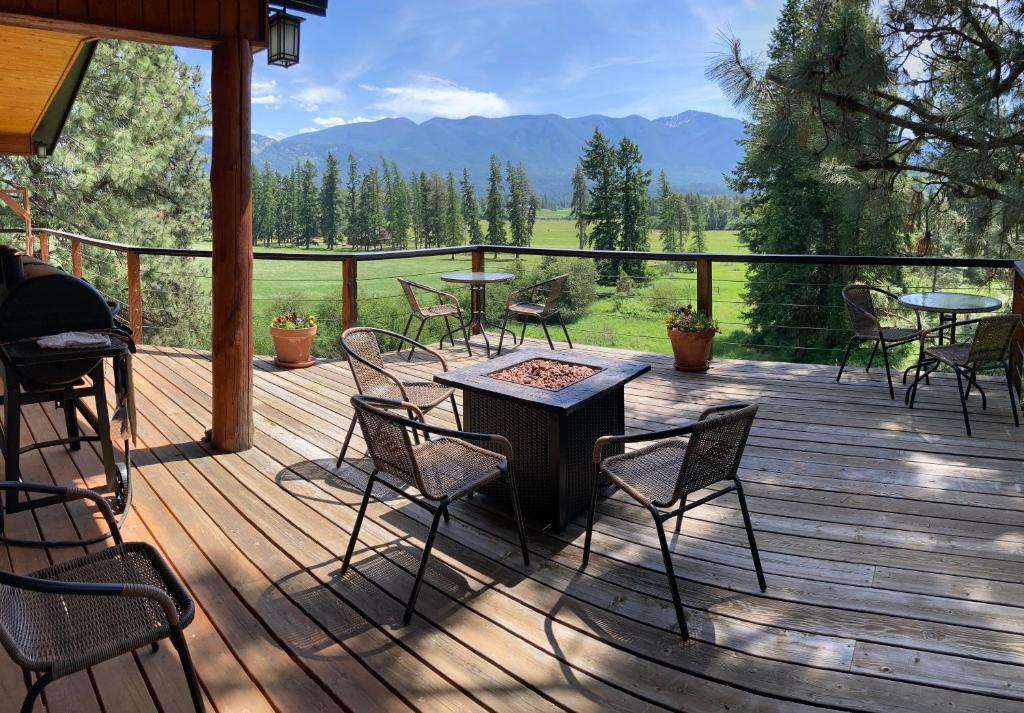a deck with chairs and a table and a grill at Hideaway Ranch in Bonners Ferry
