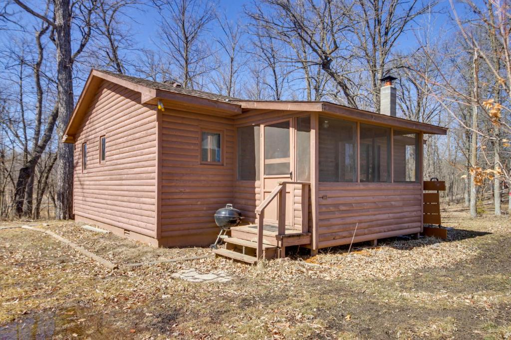 une petite cabine avec une terrasse couverte dans un champ dans l'établissement Wooded Park Rapids Cabin Lake Access, Boat Slip!, à Arago