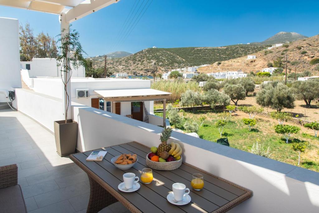 a table with a bowl of fruit on the balcony of a house at Seacret House Sifnos in Faros