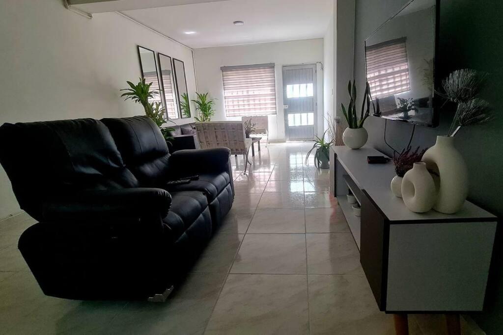 sala de estar con sofá negro y mesa en Medellín Casa central Envigado frontera poblado en Envigado