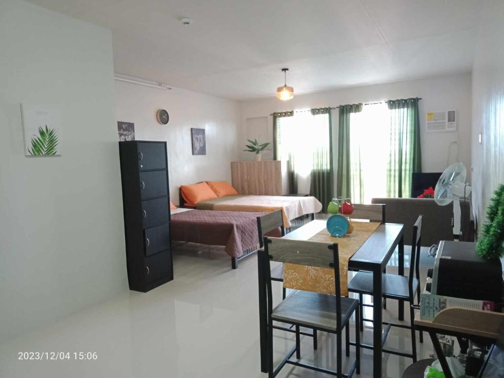 una sala de estar con una cama y un sofá en Cozy Studio with pool, en Puerto Princesa City