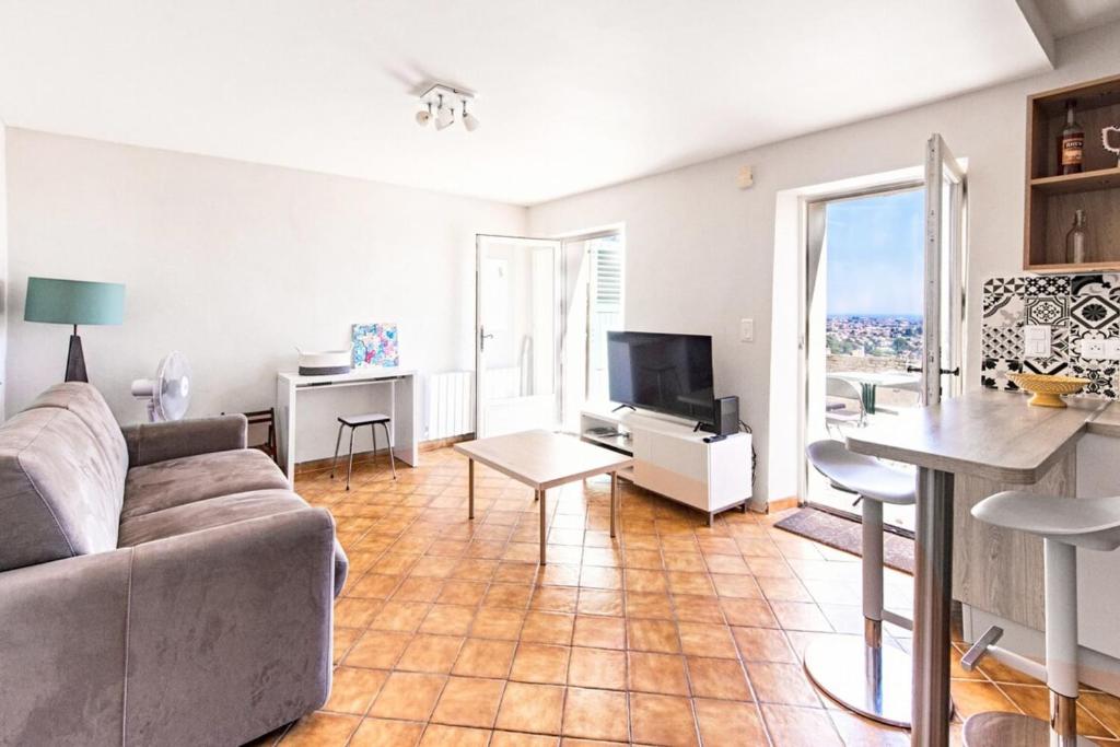 een woonkamer met een bank en een tv bij Barri furnished flat in Cagnes-sur-Mer