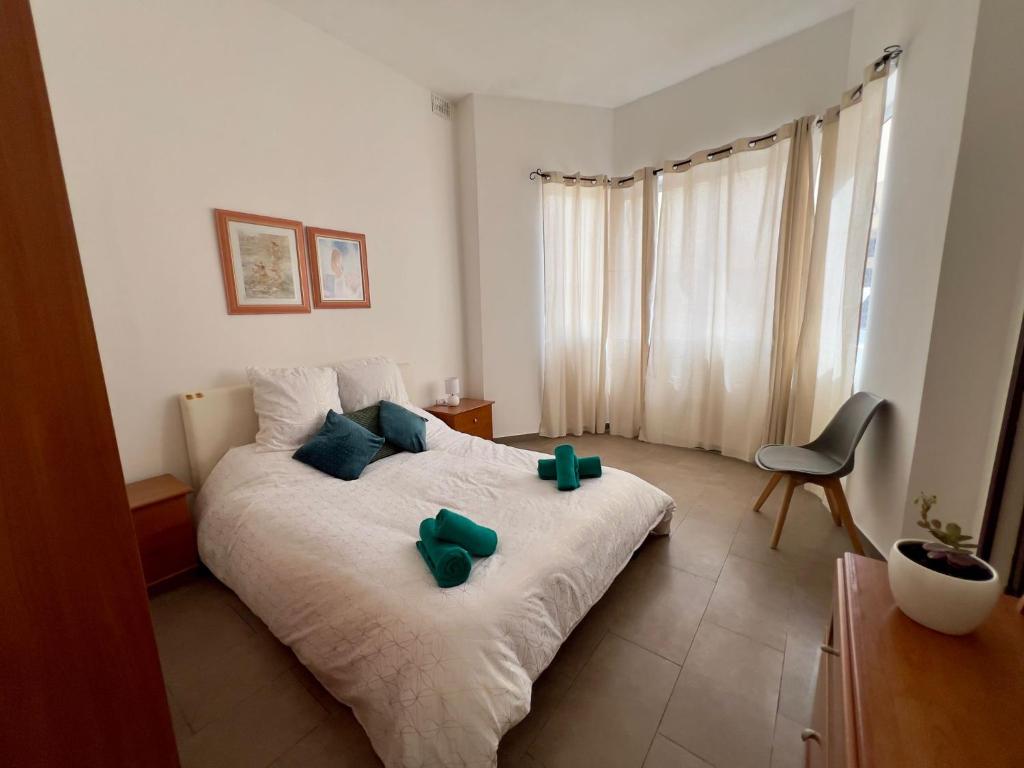 Un dormitorio con una cama con arcos verdes. en Esperjenza Apartment St Julians, en Paceville