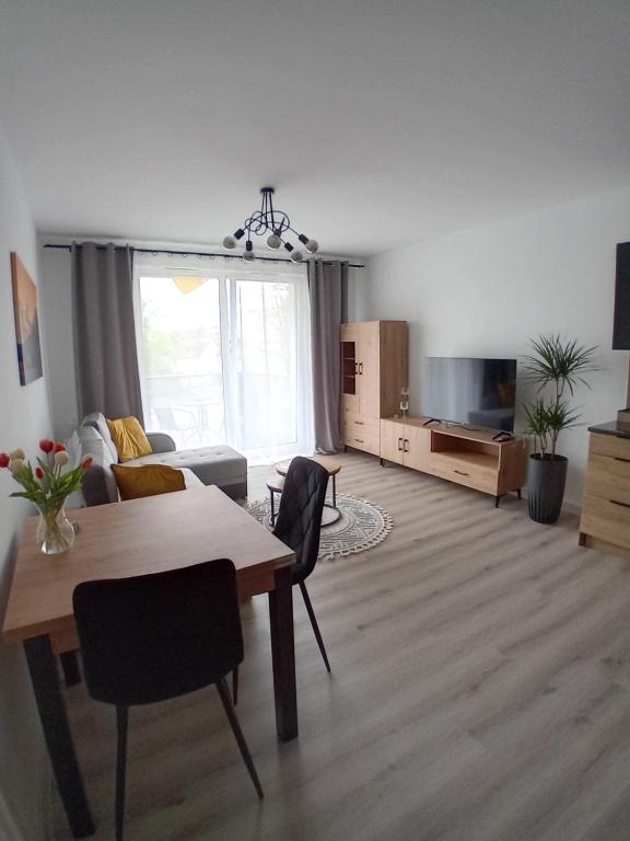 ein Wohnzimmer mit einem Tisch und einem Sofa in der Unterkunft Apartament Akacjowa in Goleniów