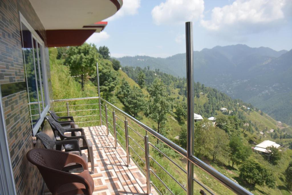 a balcony with chairs and a view of the mountains at Eagle Nest Cottage, Kala Bagh in Nathia Gali