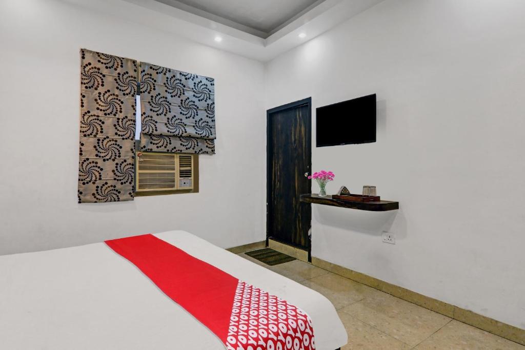 1 dormitorio con 1 cama con manta roja en Capital O Affection Inn, en Chinhat