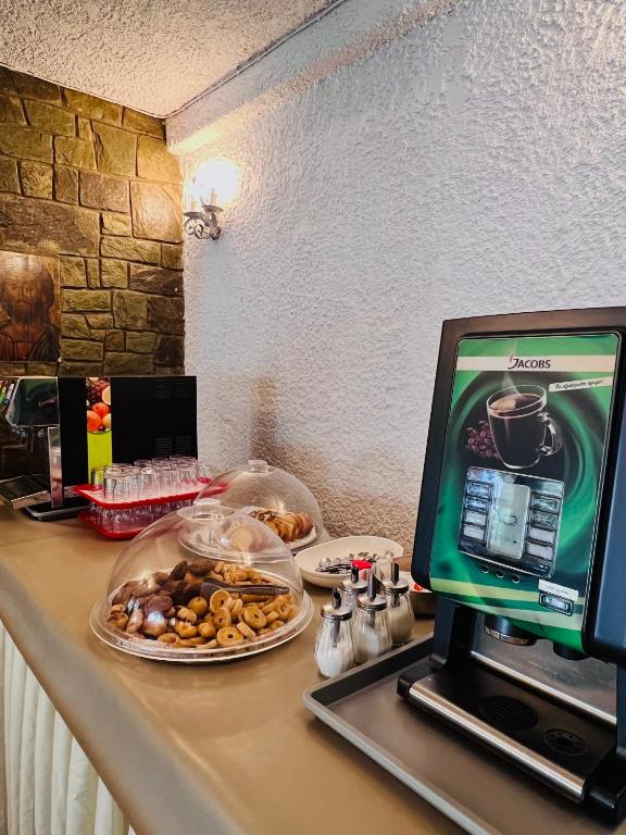 a desk with a computer and a plate of food at Karteros Hotel in Karteros