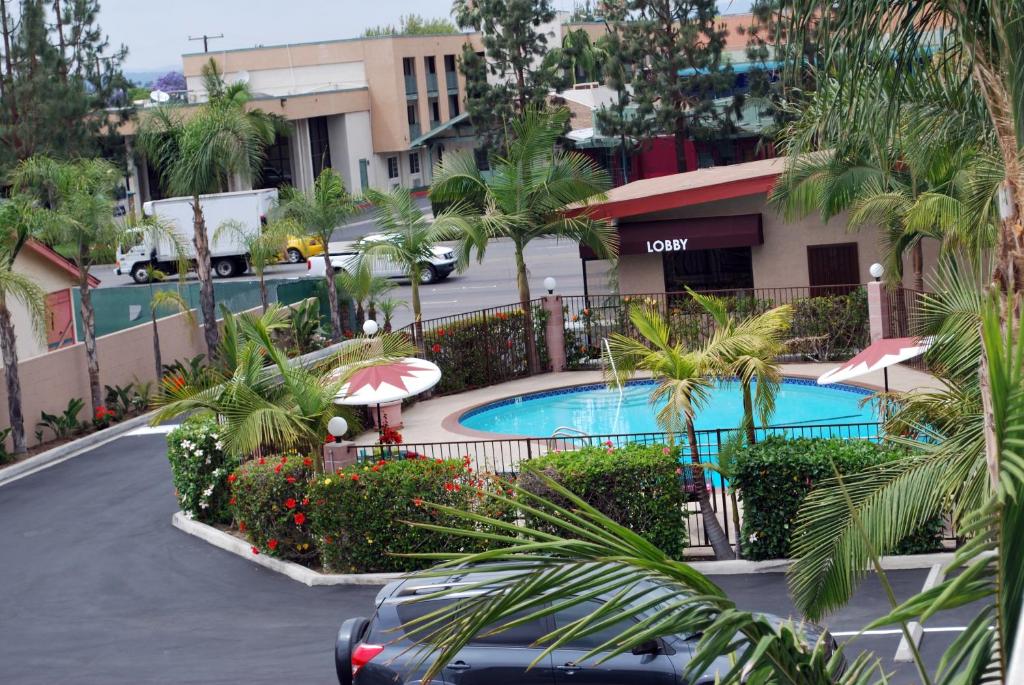 a car driving down a street with two swimming pools at Budget Inn Anaheim near Disneyland Drive in Anaheim