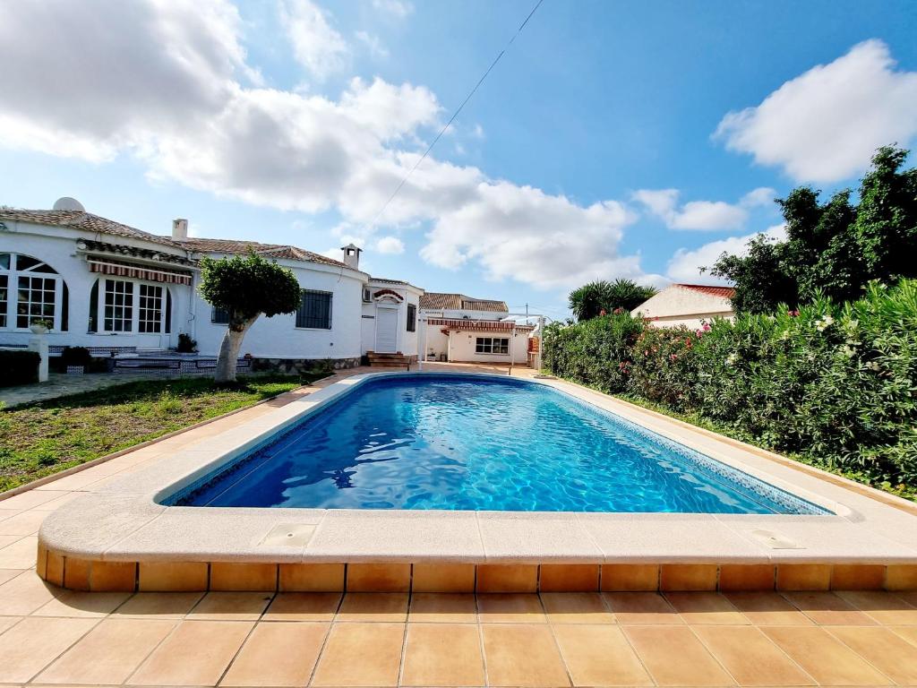 a swimming pool in front of a house at Charming Villa With Own Pool Urb La Siesta in La Mata