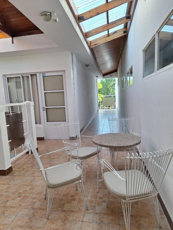 a patio with a table and chairs and a television at Departamentos MR in Villa Elisa