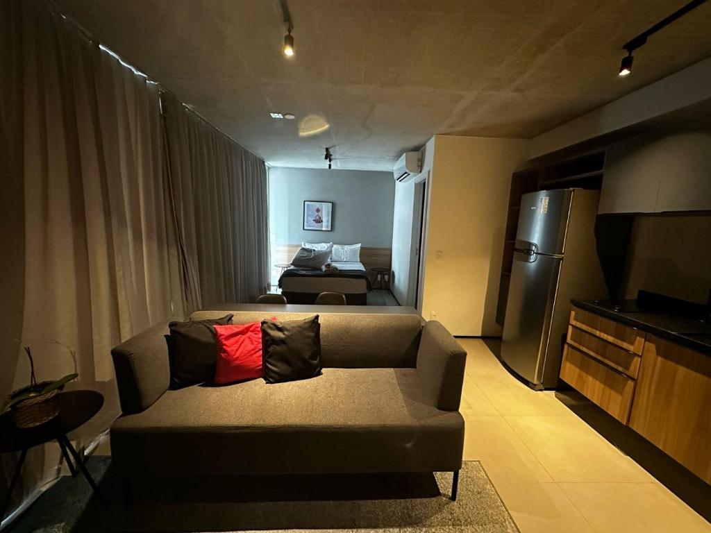 a living room with a couch and a refrigerator at Flat Frei Caneca in Sao Paulo